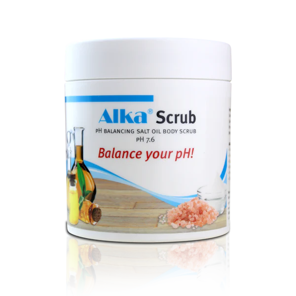 A white container labeled "Alka® Scrub" described as a salt and oil body scrub, is placed on a wooden surface with the phrase “Balance your pH!” shown; available at Fisa Health.