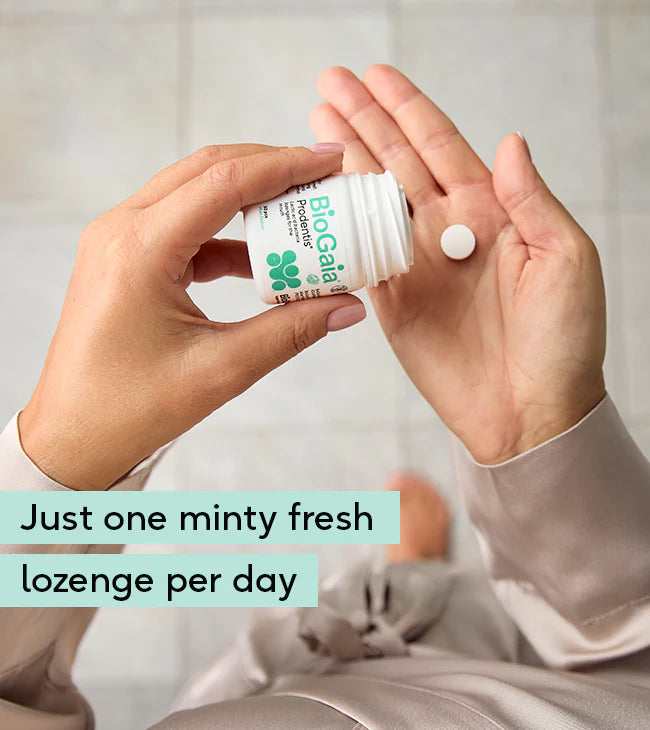 A person pours a BioGaia Prodentis Lozenges 30s tablet into their hand. The packaging shows the BioGaia brand name and product details. Available at Fisa Health.