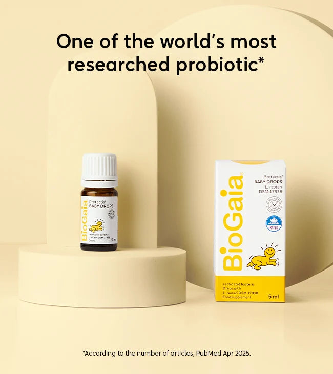 A bottle and box of BioGaia Protectis Baby Drops 5ml are displayed on beige platforms. The brand name "BioGaia" and product name are visible on the packaging, available at Fisa Health.