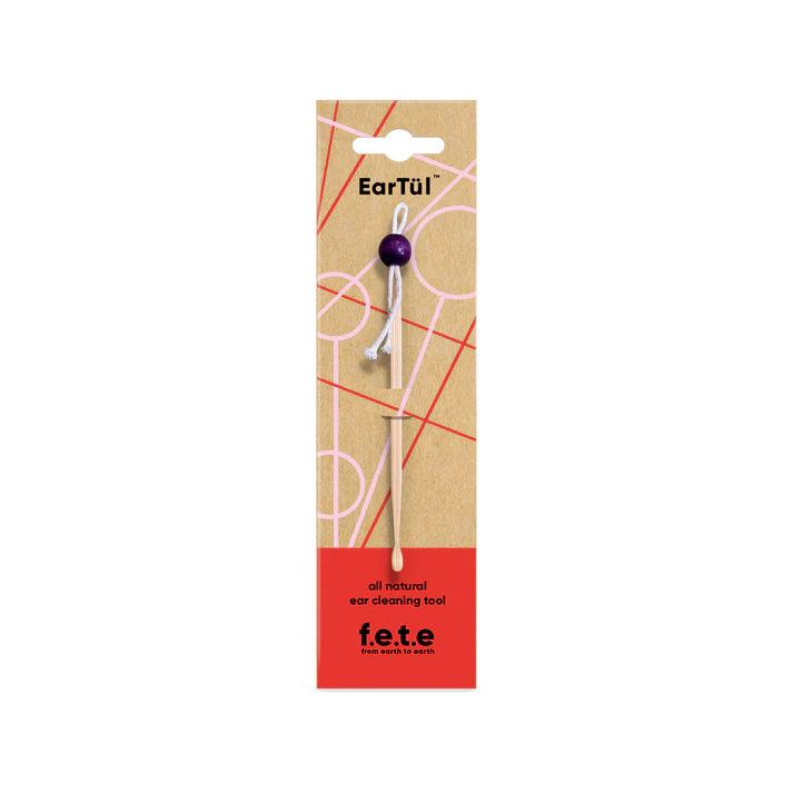 F.E.T.E. Bamboo EarTül ear care tool with a purple handle is displayed on a geometric background; labeled as an all natural ear cleaner, available at Fisa Health.