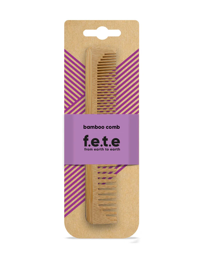 F.E.T.E. Natural Bamboo Comb in eco-friendly packaging with a purple label, displayed against a brown and purple striped background, available at Fisa Health.
