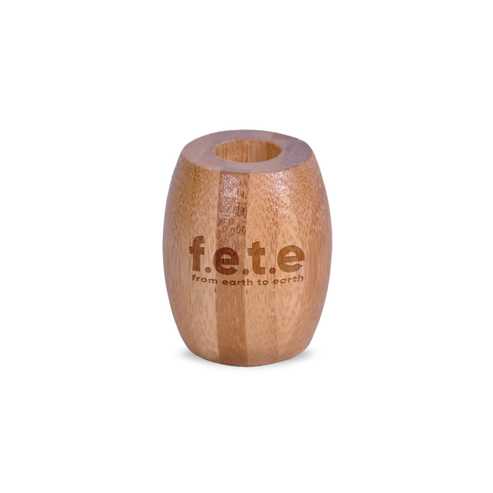 F.E.T.E. Eco-Friendly Bamboo Toothbrush Stand is a small, cylindrical bamboo holder engraved with "f.e.t.e from earth to earth," designed as a sustainable bathroom accessory, available at Fisa Health.