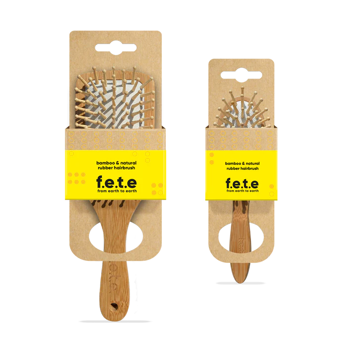 Two F.E.T.E. Bamboo & Natural Rubber Hairbrushes, one large and one small, displayed in eco-friendly cardboard packaging, available at Fisa Health.