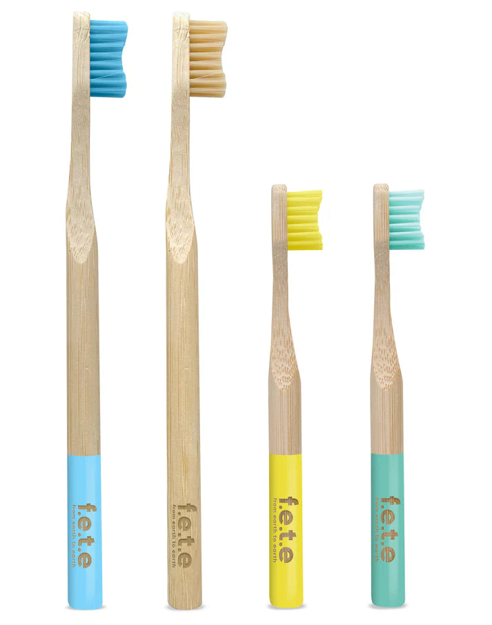 F.E.T.E. Family Pack includes two adult and two children’s bamboo toothbrushes in blue, yellow, and green, standing upright on a white background, available at Fisa Health.