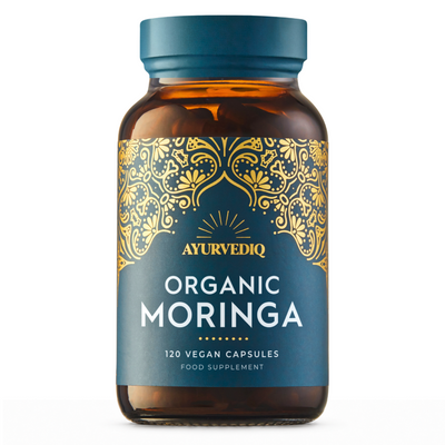 A brown glass bottle labeled Ayurvediq Organic Moringa 120 Vegan Capsules with a blue label and gold pattern at the top, available at Fisa Health.