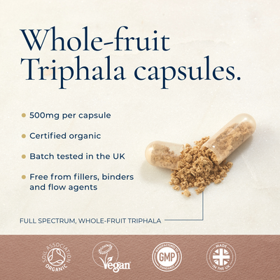 Two clear capsules with brown powder on a beige surface. Text displays Ayurvediq Organic Triphala 120 Vegan Capsules—Ayurvedic, UK batch tested, available at Fisa Health.