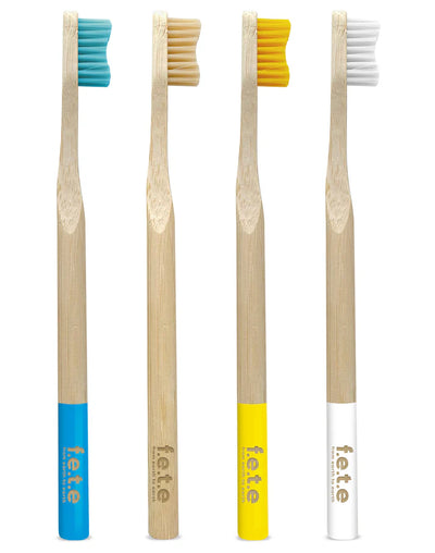 The F.E.T.E. Multipack features four medium soft, biodegradable bamboo toothbrushes with colored bristles and handles in blue, beige, yellow, and white, available at Fisa Health.