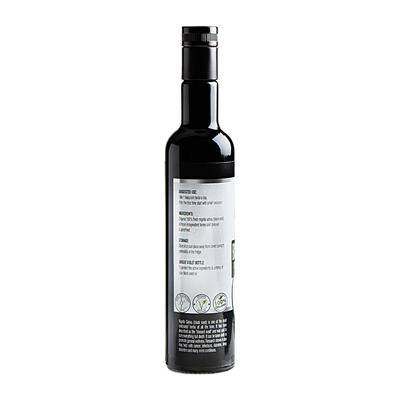A dark glass bottle with a black cap and a white label displaying "Black Seed Oil Cold-Pressed Nigella Sativa," viewed from the back, available at Fisa Health.