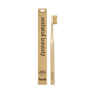 F.E.T.E. Single Medium Bamboo Toothbrush with a biodegradable handle placed next to its eco-friendly cardboard packaging, available at Fisa Health.