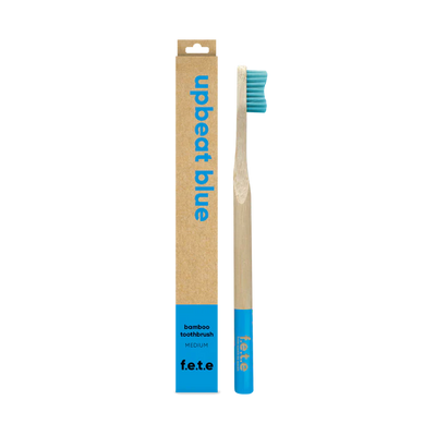 F.E.T.E. Single Medium Bamboo Toothbrush with a biodegradable handle, blue bristles and tip, packaged in an eco-friendly "upbeat blue" box, available at Fisa Health.