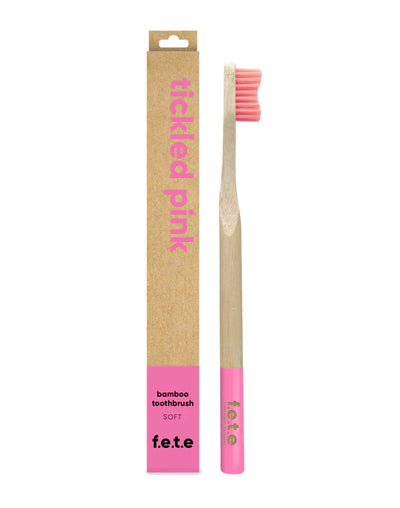 The F.E.T.E. Single Soft Bamboo Toothbrush has pink bristles, a pink tip, and eco-friendly packaging labeled "Tickled Pink," available at Fisa Health.