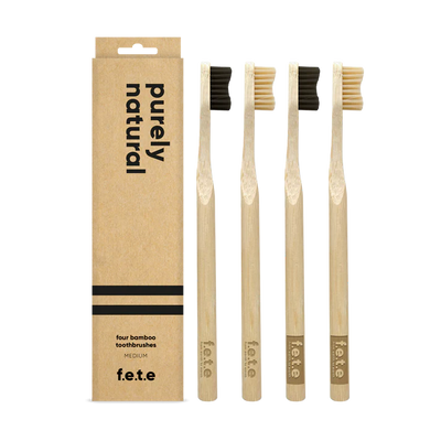 F.E.T.E. Natural Vegan Medium Bamboo Toothbrushes with charcoal bristles, eco-friendly design, pack of 4, displayed in a row on a white background, available at Fisa Health.