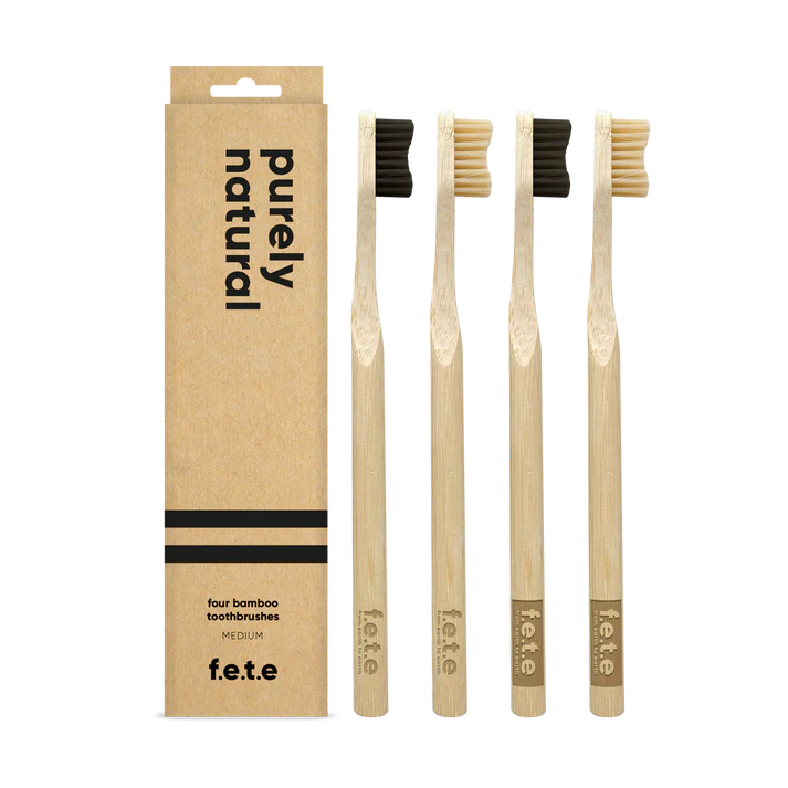 F.E.T.E. Natural Vegan Medium Bamboo Toothbrushes with charcoal bristles, eco-friendly design, pack of 4, displayed in a row on a white background, available at Fisa Health.