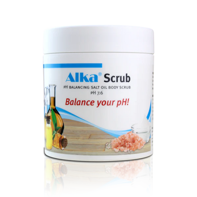 A white container labeled "Alka® Scrub" described as a salt and oil body scrub, is placed on a wooden surface with the phrase “Balance your pH!” shown; available at Fisa Health.