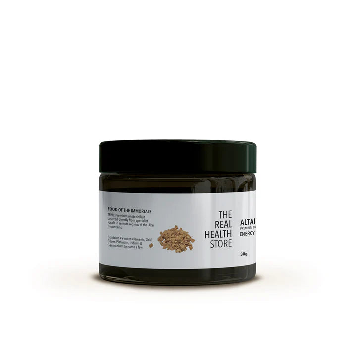 A dark jar with a white label and black lid displaying the text "Altai White Shilajit, Premium Brakshun Stone Oil 30g" with product details and several small brown pieces nearby, available at Fisa Health.