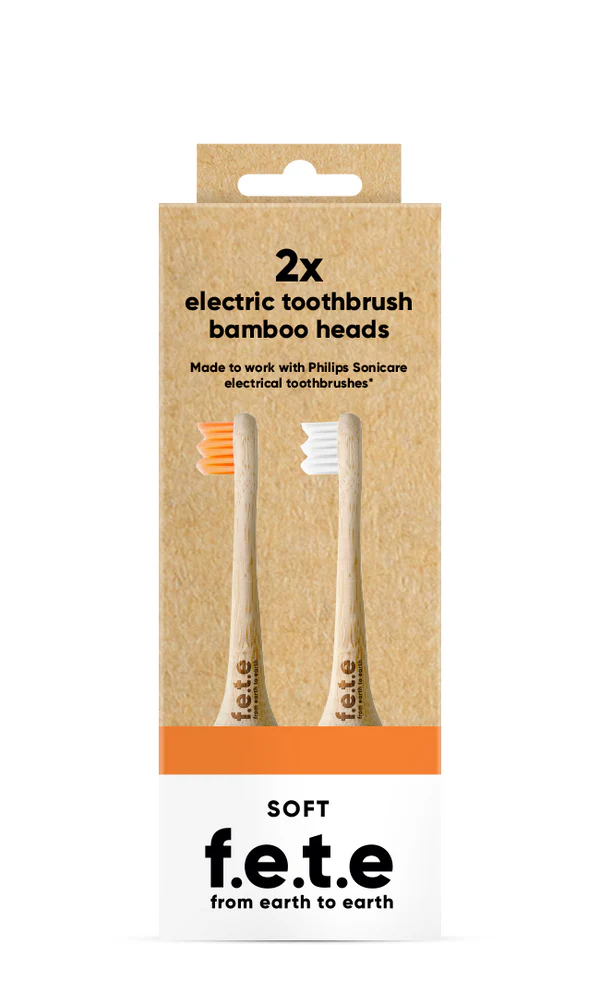 Two F.E.T.E Electric Compatible bamboo toothbrush heads, one with orange bristles and one with white bristles, in eco packaging labeled soft, available at Fisa Health.