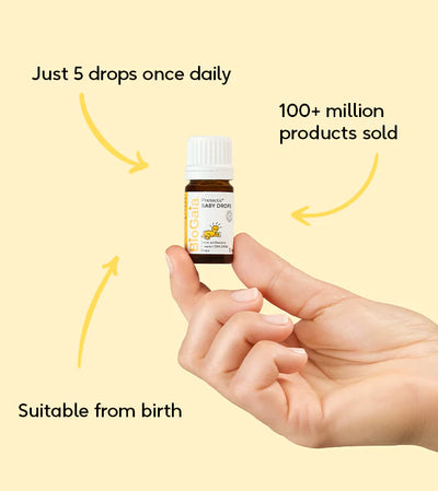 A hand holds a box labeled "BioGaia Protectis Baby Drops 5ml", showing a cartoon baby and product information. Available at Fisa Health.