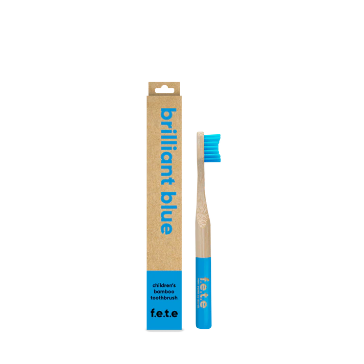 A F.E.T.E. Children's Bamboo Toothbrush with blue bristles and tip, next to its brown box labeled "Brilliant Blue", available at Fisa Health.