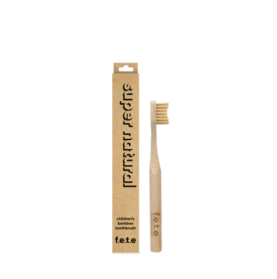 The F.E.T.E. Children's Bamboo Toothbrush is shown upright next to its brown box labeled “children's bamboo toothbrush” on a white background, available at Fisa Health.