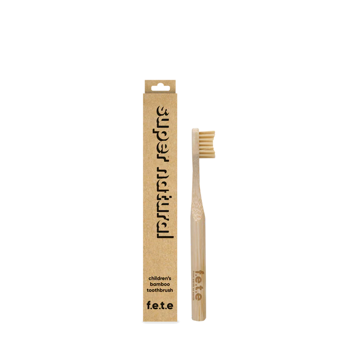 The F.E.T.E. Children's Bamboo Toothbrush is shown upright next to its brown box labeled “children's bamboo toothbrush” on a white background, available at Fisa Health.