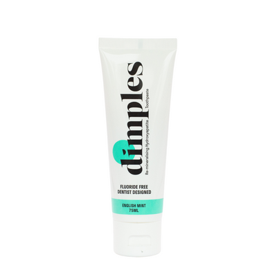 A 75ml white tube of Dimples Hydroxyapatite Toothpaste, English mint flavor, with green accents and bold black vertical text, available at Fisa Health.