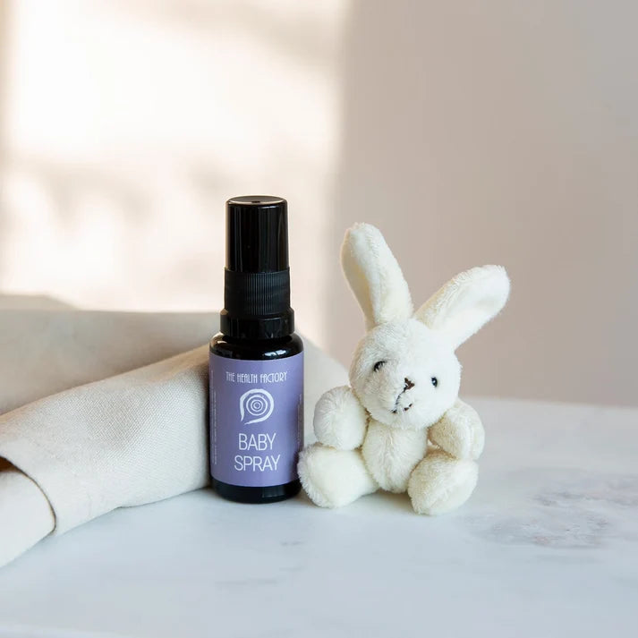 A 15ml Nano Zinc Baby Spray by The Health Factory is placed beside a white plush bunny on a light surface with a neutral background, available at Fisa Health.