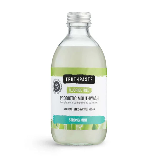 Truthpaste Strong Mint Probiotic Mouthwash in a natural, vegan, fluoride-free formula is shown with mint leaves and product packaging, available at Fisa Health.