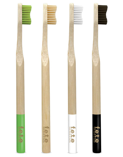 F.E.T.E. Multipack Firm Bamboo Toothbrushes (Pack of 4) displayed upright, each with a different colored handle and the label f.e.t.e. on the handle, available at Fisa Health.